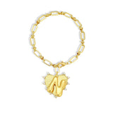 Gold chain bracelet with a heart-shaped charm and initial letter N over the heart charm on a white background
