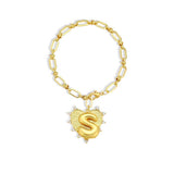 Gold chain bracelet with a heart-shaped charm and initial letter S over the heart charm on a white background