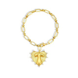 Gold chain bracelet with a heart-shaped charm and initial letter T over the heart charm on a white background