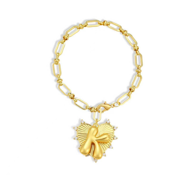 Gold chain bracelet with a heart-shaped charm and initial letter K over the heart charm on a white background