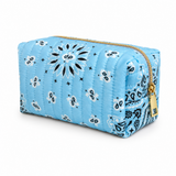 a quilted bandana print cosmetic case in blue color with gold zipper on white background