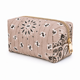A quilted cosmetic pouch in a taupe beige color with a black and white paisley bandana print and gold-tone zipper hardware, shown on a plain white background.