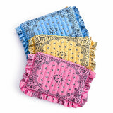 3 of bandana print ruffled around quilted pouches in pink, yellow and blue on white background