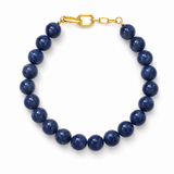 Blue beaded bracelet with a gold clasp on a white background