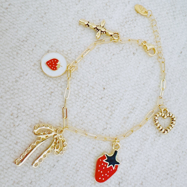 Gold charm bracelet with strawberry, heart, and bow – romantic playful bracelet