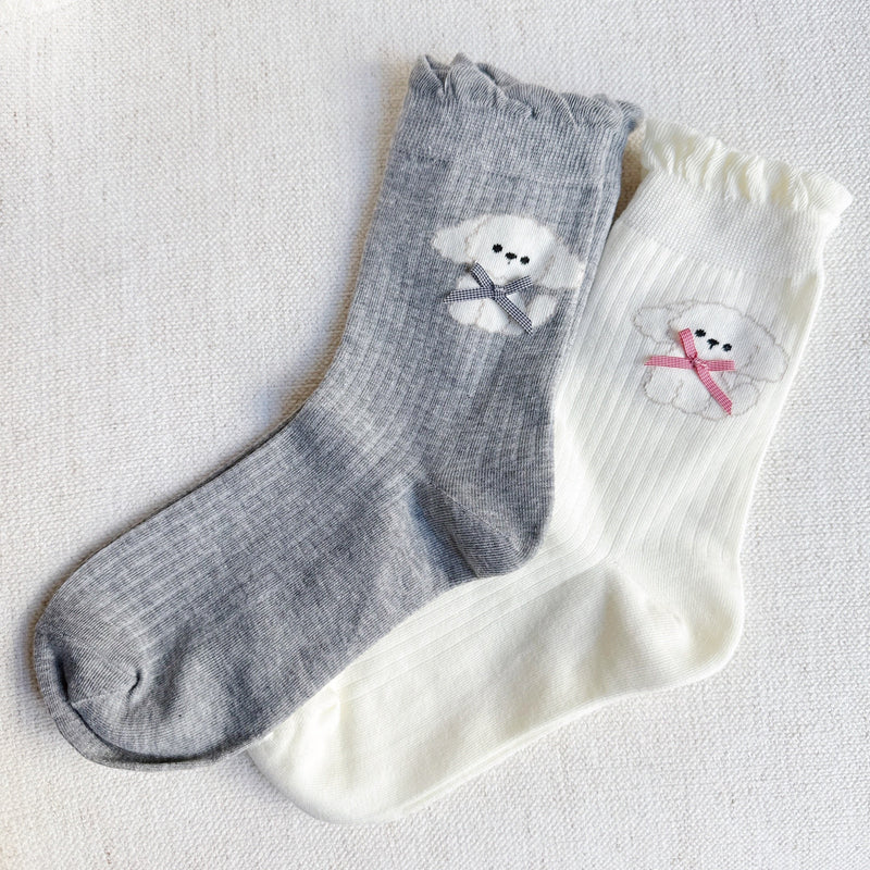 Set of two crew-length socks featuring charming embroidered Bichon Frise puppy design. Each pair showcases a soft color and is crafted from a stretchy & cozy material, perfect for everyday wear with a playful and cute flair.