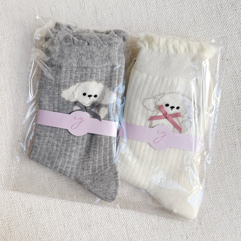 Set of two crew-length socks featuring charming embroidered Bichon Frise puppy design. Each pair showcases a soft color and is crafted from a stretchy & cozy material, perfect for everyday wear with a playful and cute flair.