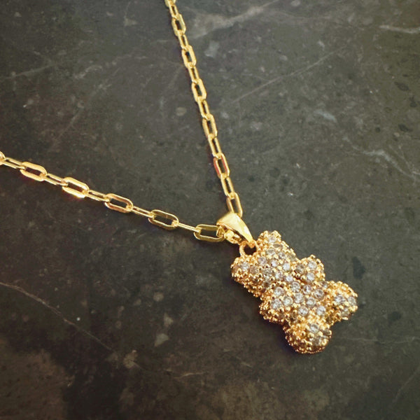 Sparkling gold-tone necklace featuring a playful bear-shaped pendant encrusted with shimmering rhinestones.