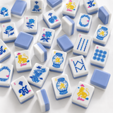 A set of Mahjong tiles arranged on a white surface, showing white tiles with blue borders and various blue, yellow, and red printed symbols and illustrations.