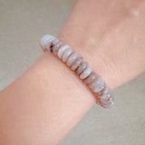 Stretch bracelet made of natural stone disc beads in soft blush, beige, and taupe tones arranged in a gradient pattern