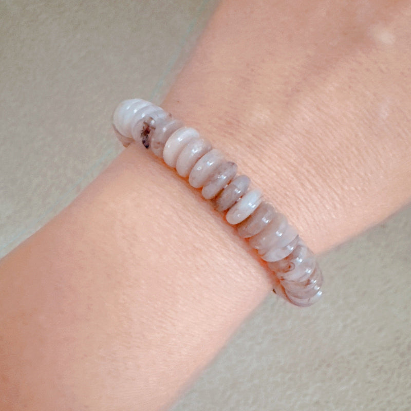 Stretch bracelet made of natural stone disc beads in soft blush, beige, and taupe tones arranged in a gradient pattern