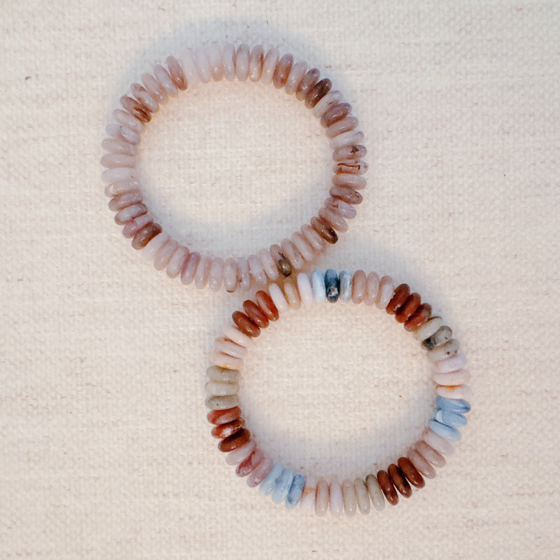 Stretch bracelet made of natural stone disc beads in soft blush, beige, and taupe tones arranged in a gradient pattern