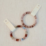Stretch bracelet made of natural stone disc beads in soft blush, beige, and taupe tones arranged in a gradient pattern