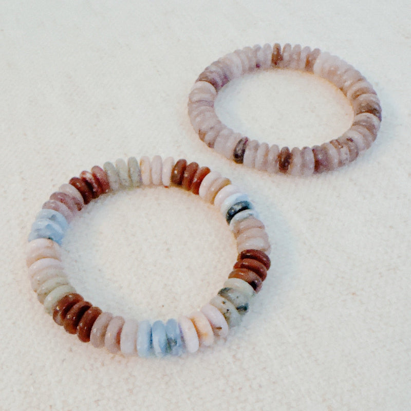 Stretch bracelet made of natural stone disc beads in soft blush, beige, and taupe tones arranged in a gradient pattern