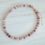 Beaded necklace made with natural stone disc beads in warm blush, beige, and soft brown tones arranged in a smooth, gradient pattern.