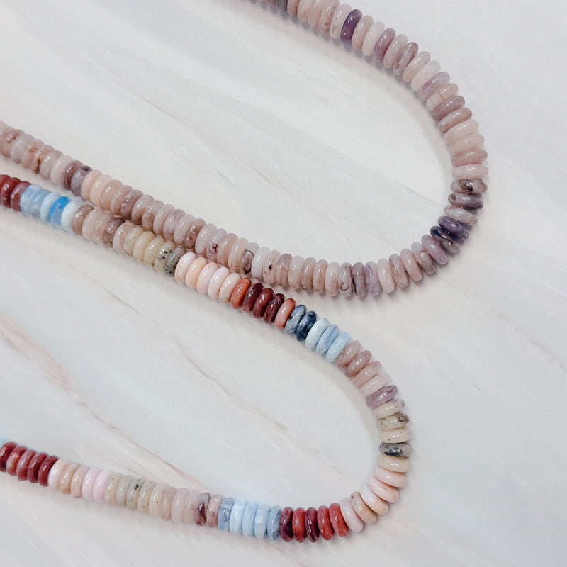 Beaded necklace made with natural stone disc beads in warm blush, beige, and soft brown tones arranged in a smooth, gradient pattern.