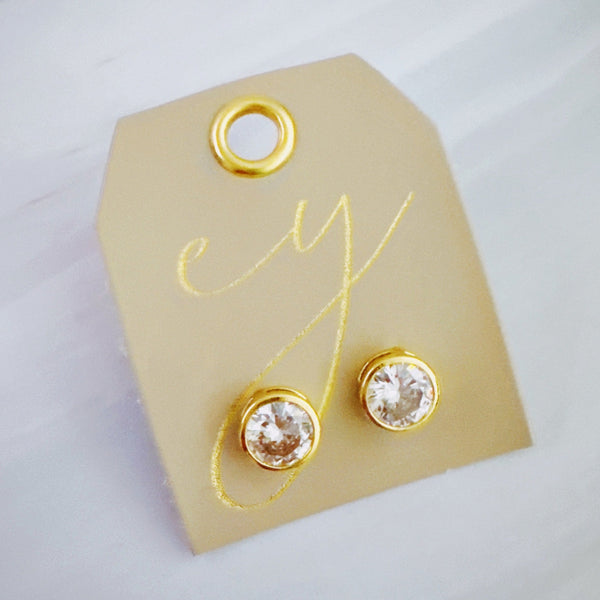 Statement stud earrings featuring bold bezel-set stones, designed to deliver striking sparkle and a sleek, modern silhouette for everyday elegance or special occasions.