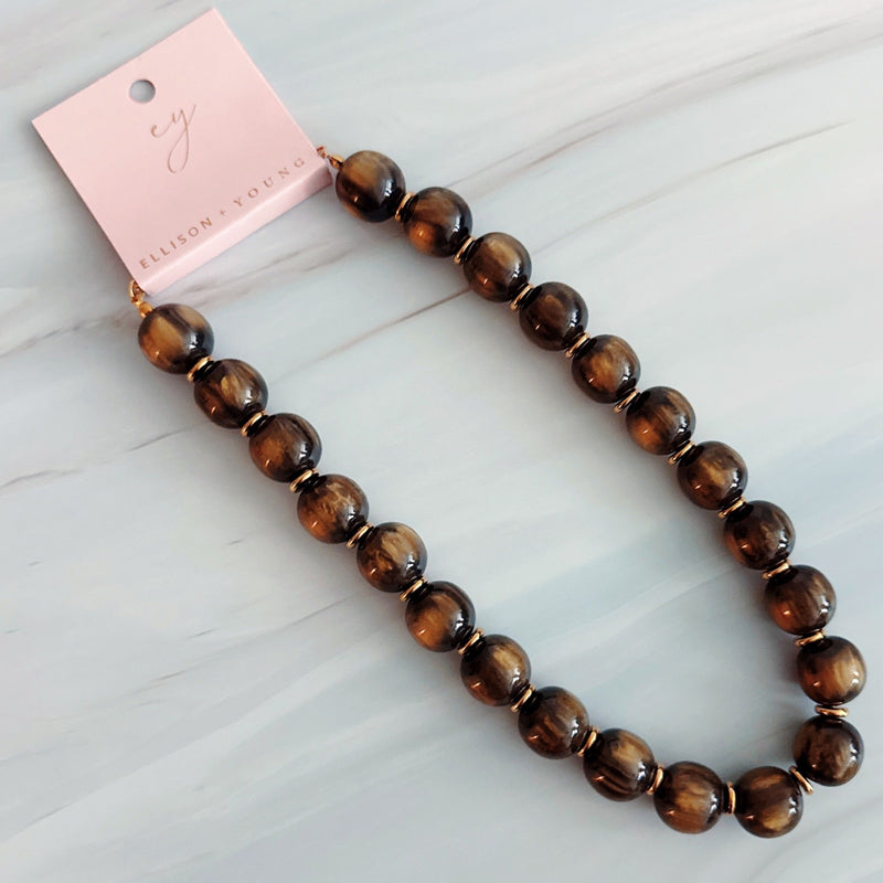 Chunky round bead necklace featuring high-shine polished sphere beads arranged in a single statement strand, showcasing a bold and modern look
