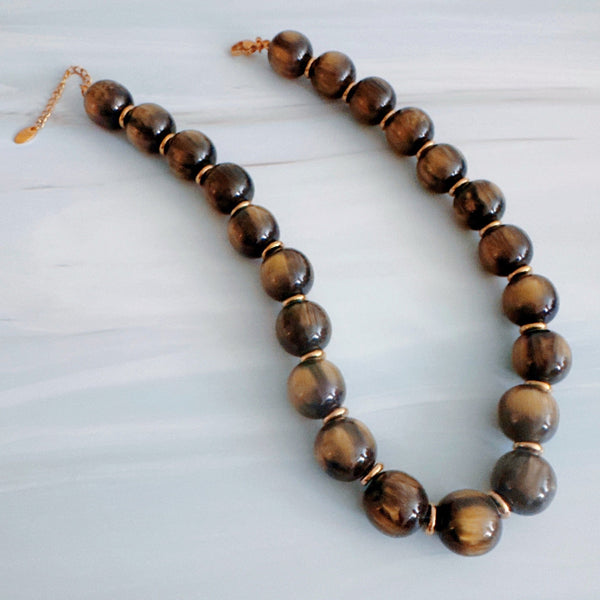 Chunky round bead necklace featuring high-shine polished sphere beads arranged in a single statement strand, showcasing a bold and modern look