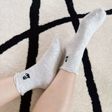 Set of two crew-length socks featuring playful cat and dog designs on a soft fabric. Each pair showcases a different animal-themed design with charming expressions and subtle color, adding a whimsical and cozy touch to everyday outfits.