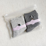 Set of two crew-length socks featuring playful cat and dog designs on a soft fabric. Each pair showcases a different animal-themed design with charming expressions and subtle color, adding a whimsical and cozy touch to everyday outfits.