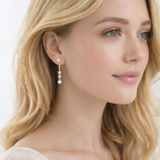 Elegant gold drop earrings featuring two luminous pearls in a contemporary linear design. The Celeste Double Pearl Earrings combine timeless sophistication with a modern gold finish, perfect for both casual and formal wear.
