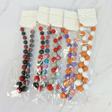 Colorful beaded necklaces in clear packaging on a white background