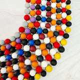 Colorful beaded necklace on a light wooden surface