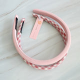 A set of padded fabric headbands in assorted pastel and plaid designs, including soft pink, green tones. Each headband features a cushioned, textured surface that blends solid and patterned fabrics for a stylish, comfortable everyday accessory.