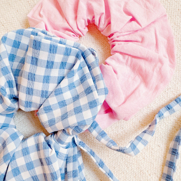 Set of two hair scrunchies featuring bold checkered patterns with elegant trailing ribbons—perfect for adding a playful yet polished touch to any hairstyle.