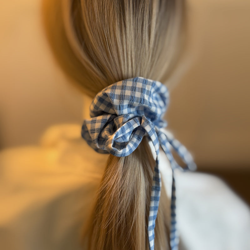 Set of two hair scrunchies featuring bold checkered patterns with elegant trailing ribbons—perfect for adding a playful yet polished touch to any hairstyle.