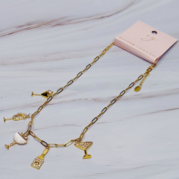 Gold-tone necklace featuring multiple celebratory charms including a champagne bottle, a drinking glass, and, arranged in a layered style for a fun and festive look.