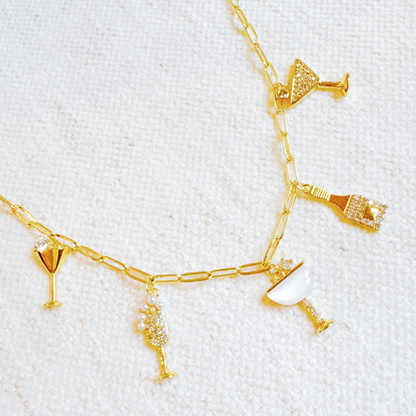 Gold chain necklace featuring multiple celebratory charms including a champagne bottle, flute glass, and martini glasses, creating a festive and playful look.