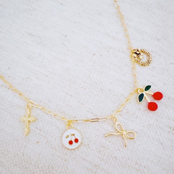 Gold necklace with cherry, cross, and bow charm – playful Y2K accessory