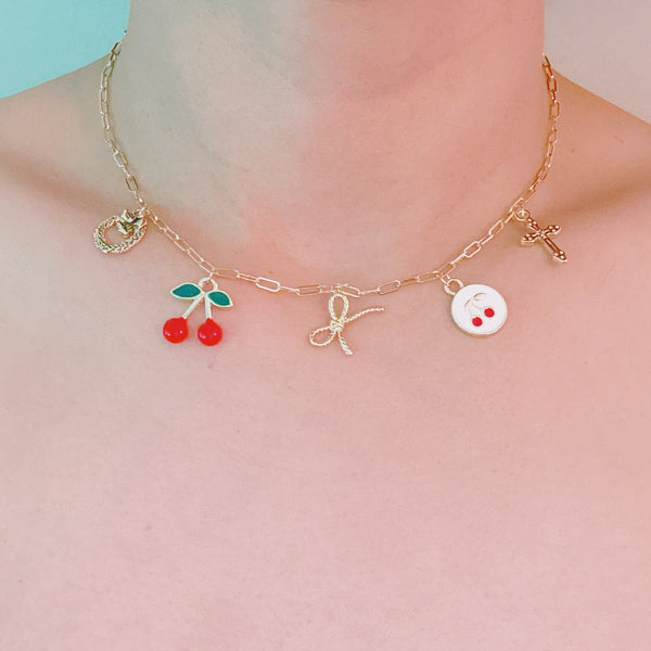 Gold necklace with cherry, cross, and bow charm – playful Y2K accessory