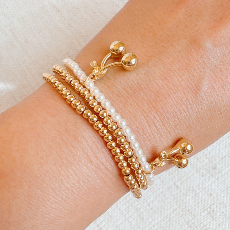  Set of three stretch bracelets adorned with dangling cherry charms—adding a sweet and playful flair to your accessory collection.