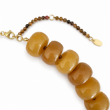Bracelet with brown beads and gold clasp on a white background