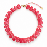 A beaded necklace made of polished pink disc beads with a small gold clasp and extender chain, photographed on a clean white background.