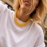 Woman wearing a white t-shirt and yellow bracelet with a blurred background