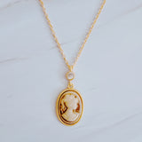 Classic gold chain necklace featuring a vintage-inspired cameo pendant with an ornate gold-tone frame and adjustable clasp closure.