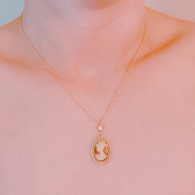 Classic gold chain necklace featuring a vintage-inspired cameo pendant with an ornate gold-tone frame and adjustable clasp closure.