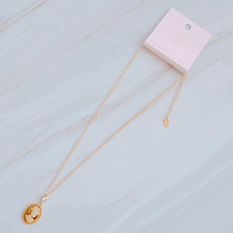Classic gold chain necklace featuring a vintage-inspired cameo pendant with an ornate gold-tone frame and adjustable clasp closure.