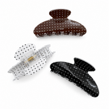 Three polka dot hair clips on a white background