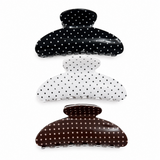 Three polka dot hair clips in black, white, and brown on a white background