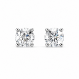A pair of round-cut solitaire stud earrings in a silver-toned four-prong setting, shown on a plain white background.