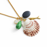 Necklace with shell, fish, and green stone pendant on a white background