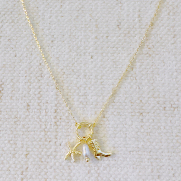 Gold-tone chain necklace adorned with a starfish charm and a western boot charm, capturing a playful blend of coastal and cowgirl vibes.
