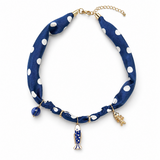 Blue polka dot necklace with gold fish charms on a white background