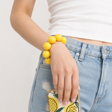Yellow large beads lanyard around wrist connected to the phone 