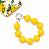 Yellow large bead phone lanyard conected to the phone